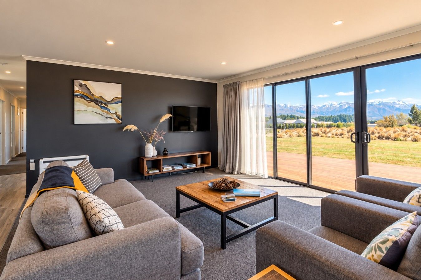 A modern living room with a sofa set, a coffee table, a TV, and a bookshelf.
