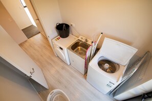 A compact laundry room with a washing machine, dryer, and sink. - Mackenzie Magic, Twizel - FREE WIFI (Twizel)