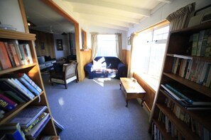 A cozy living room with a sofa, a coffee table, and bookshelves filled with books.