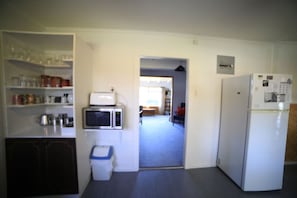A kitchen with a microwave, refrigerator, and open pantry shelves. - Home away from Home, Twizel. FREE WIFI (Twizel)