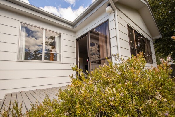 A modern house with large windows and a wooden deck.