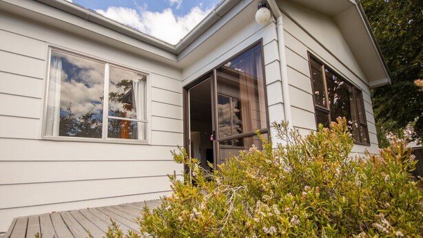 A modern house with large windows and a wooden deck. - Holiday Haven - FREE WIFI (Twizel)