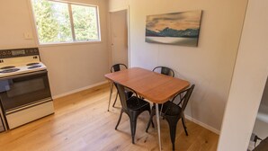 A kitchen with a stove and a dining table with four chairs. - Holiday Haven - FREE WIFI (Twizel)