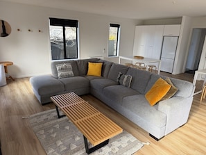 Un soggiorno moderno con un divano modulare grigio, un tavolino in legno e tappeti decorati.