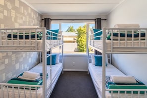 A room with bunk beds, a window with curtains, and a view of the outside. - Fantastic Family Home on Fraser -FREE WIFI -TWIZEL (Twizel)