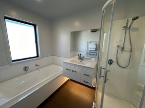 A modern bathroom with a bathtub, a shower, and a vanity with a mirror. - Big Sky, Big View - Family friendly and close to Mt Cook, FREE WIFI (Twizel)