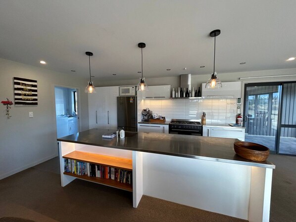 A modern kitchen with a central island, pendant lighting, and a view to the outside. - Big Sky, Big View - Family friendly and close to Mt Cook, FREE WIFI (Twizel)