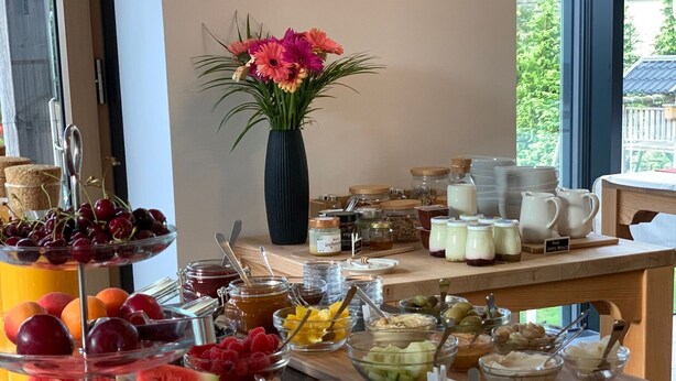 A buffet with various food items including fruits, pastries, and dairy products. - eco boutique hotel A.M.S. Beagle Bled (Gorje)