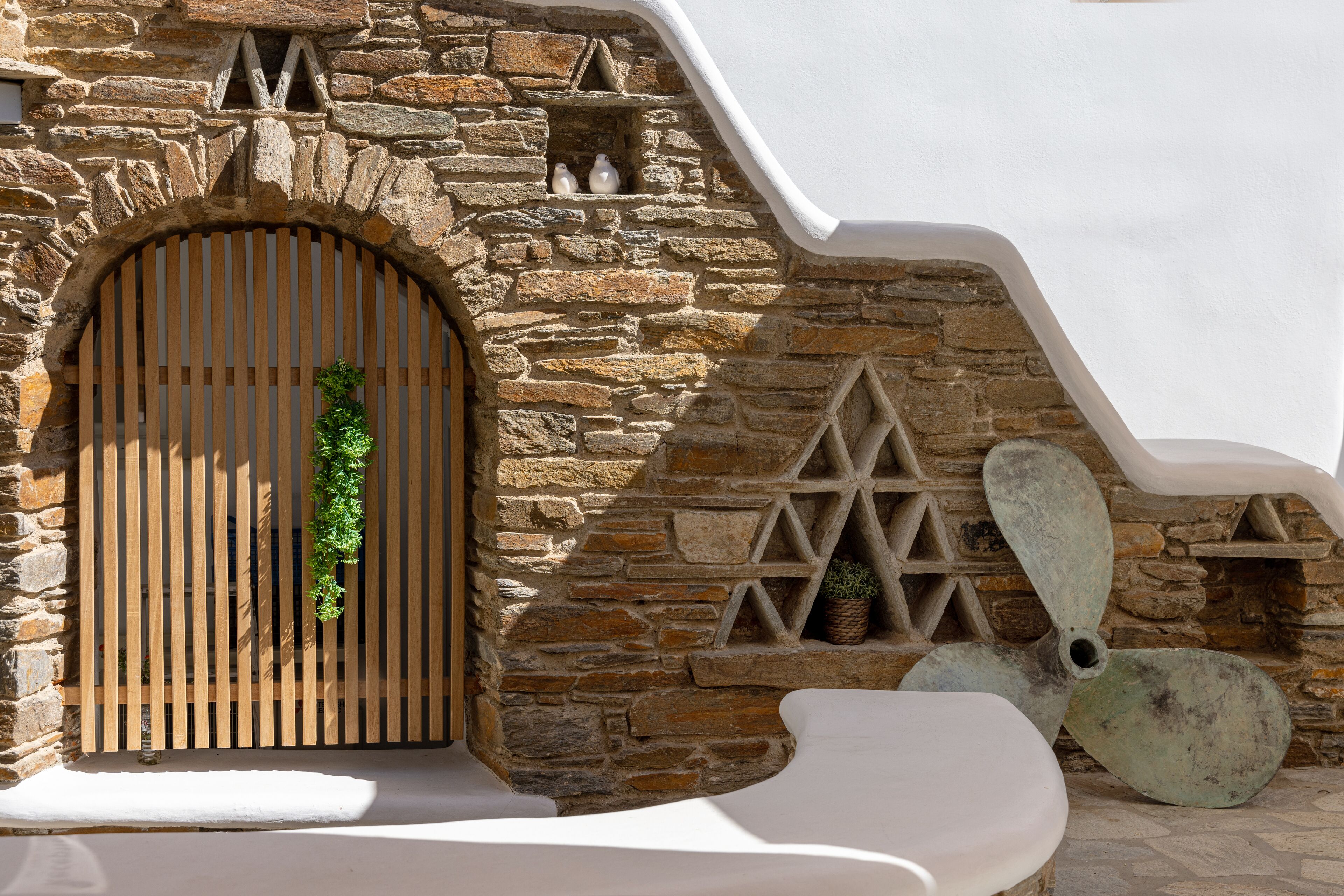 A stone wall with a wooden door and a decorative wooden panel.