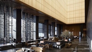 A spacious lobby with high ceilings, large windows, and modern seating arrangements.