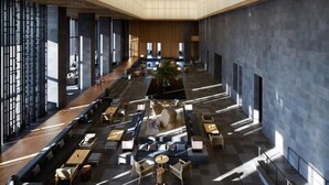 A spacious lobby with a central seating area, large windows, and a modern architectural design.