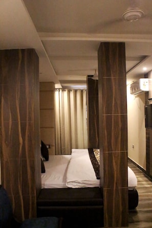 Una habitación de hotel con cama, televisión y baño con cortina de ducha.