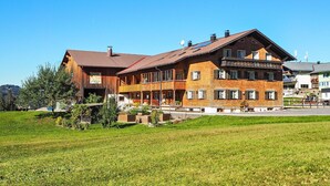 A large wooden building with multiple balconies and a well-maintained lawn in front. - Dorner Hof (Sibratsgfaell)