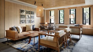 Amplia sala de estar con techo de madera, ventanas grandes, un conjunto de sofás y una mesa de centro.