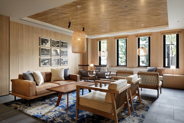 Amplia sala de estar con techo de madera, ventanas grandes, un conjunto de sofás y una mesa de centro.