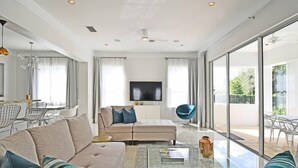 A modern living room with a sofa, a coffee table, and a TV. - Style & Luxury: Reunion Villa, Pool, Spa & Cinema (Reunion)