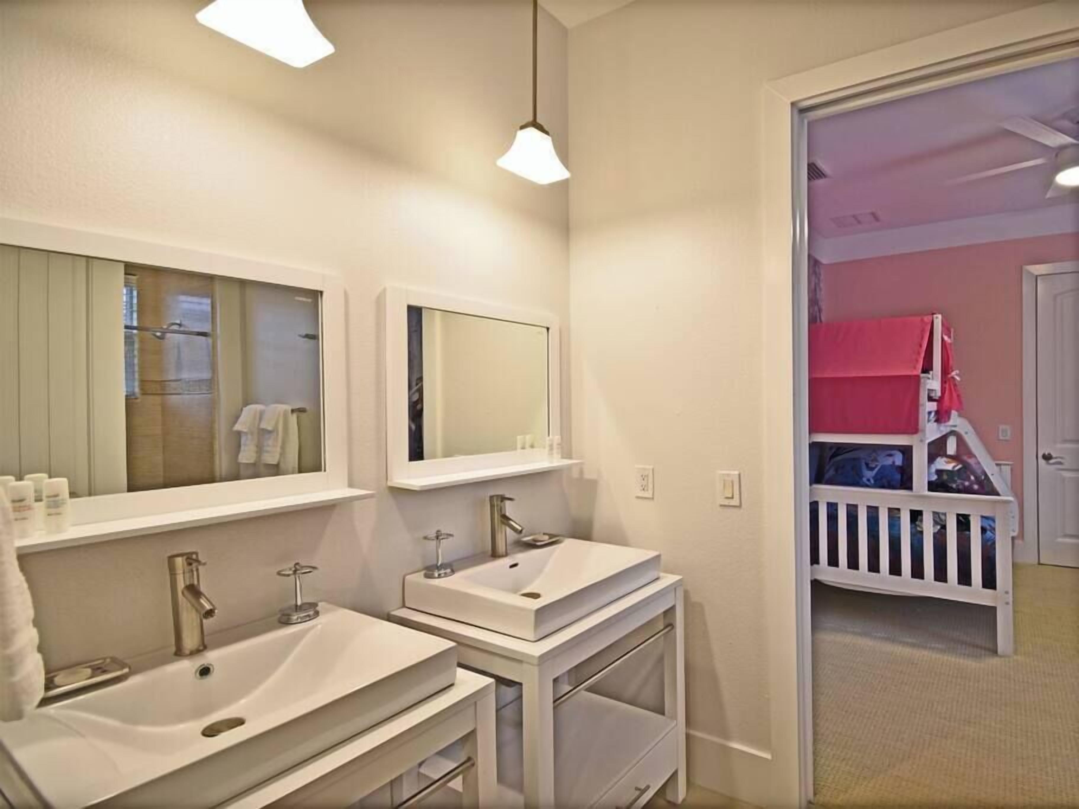 Een badkamer met twee wastafels, een opbergmeubel en een spiegel.