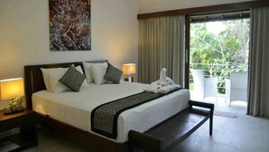 Una habitación de hotel con una cama grande, dos lámparas de noche, un cuadro en la pared y un balcón con cortinas.