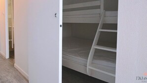 A bunk bed in a room with white walls and a wooden floor. - Studio cabin 4/5 pers, south-facing balcony, TV, equipped kitchen, ski locker (Piau-Engaly)
