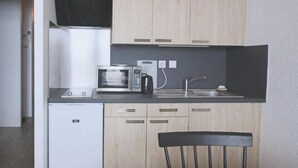 A compact kitchen with a microwave, coffee maker, and sink. - Studio cabin 4/5 pers, south-facing balcony, TV, equipped kitchen, ski locker (Piau-Engaly)