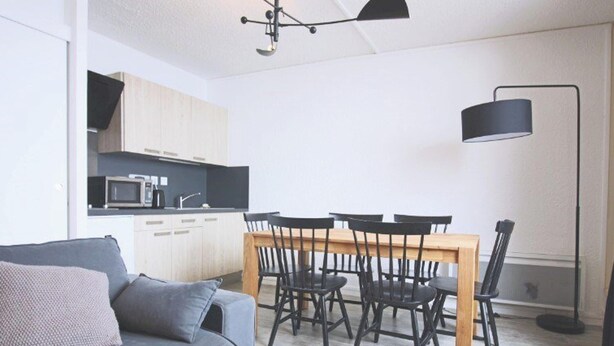 A compact living space with a dining table, chairs, a sofa, a kitchen area, and a floor lamp. - Studio cabin 4/5 pers, south-facing balcony, TV, equipped kitchen, ski locker (Piau-Engaly)