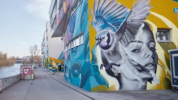 Une fresque ornant le mur extérieur d’un bâtiment, représentant un oiseau et des motifs abstraits.