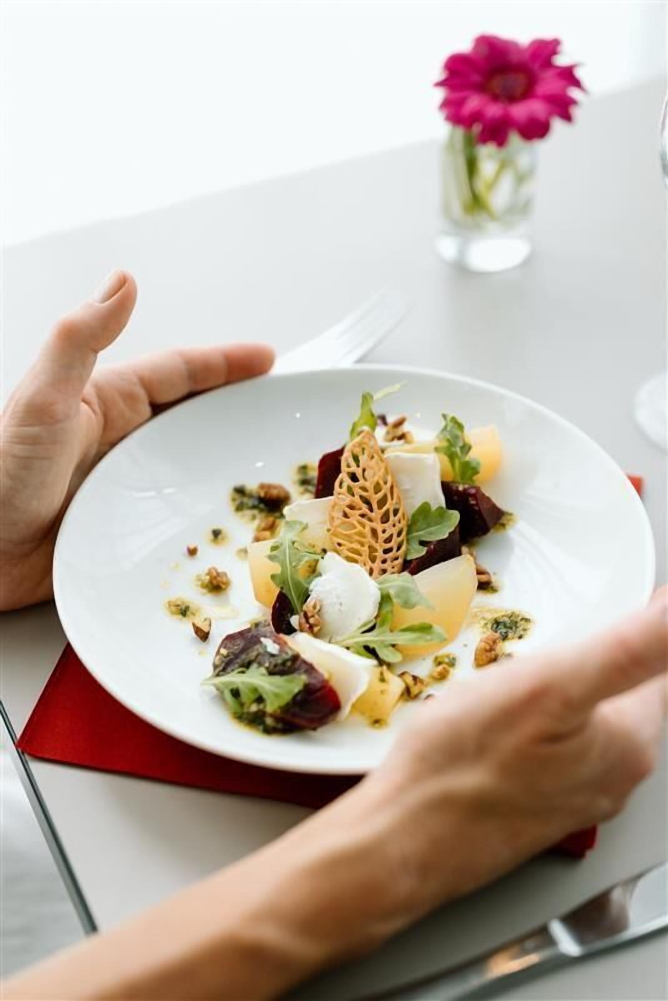 Una persona sosteniendo un plato blanco con un plato de comida.