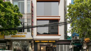 A hotel with a modern facade, a visible entrance, and a sign indicating it is a hotel. - Duc Trong Hotel (Hanoi)