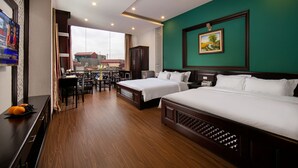 A hotel room with two beds, a dining area, and a TV. - Duc Trong Hotel (Hanoi)