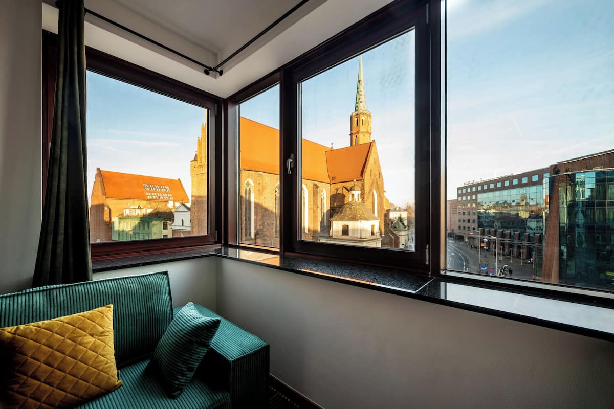 A room with a view of a church and buildings.