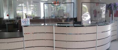A reception area with a curved counter, glass partitions, and a sign indicating a recovery area.