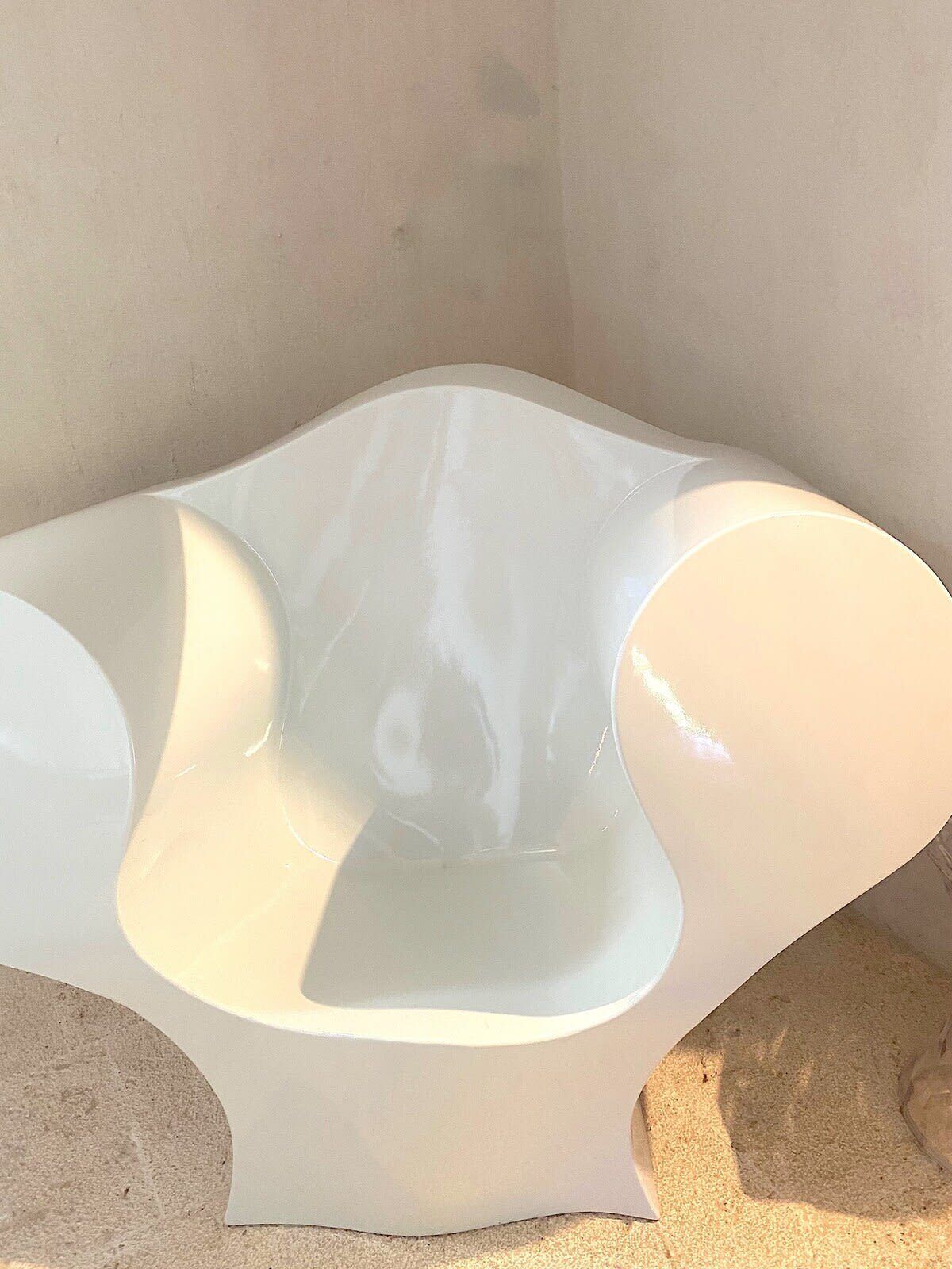 A white, modern chair with a unique, curved design.