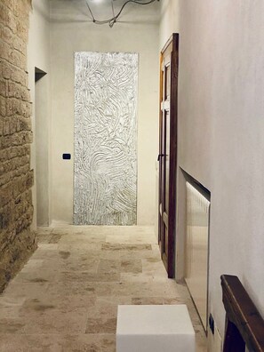 A hallway with a textured wall, a door, and a radiator. - Torre Fortunata, Splendidly Restored Medieval Tower Near Todi in Umbria (Todi)
