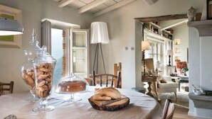 Un'area pranzo con tavolo apparecchiato per la colazione, con cestino del pane, un barattolo di biscotti e una scatola per il pane.