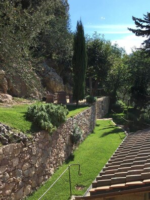 A stone retaining wall, a grassy area, and a tiled roof. - Casa Stefano/ Montagne e Mare (Metato)