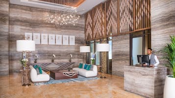 Eine moderne Lobby mit einer Rezeption, einer Sitzecke und Kunstwerken an den Wänden.
