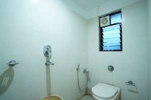 Un baño pequeño y limpio con inodoro, ducha y ventana.