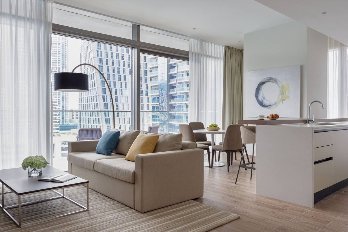 Een moderne woonkamer met een bank, salontafel en een eethoek.