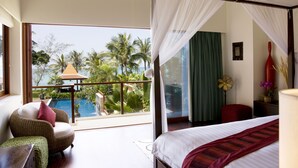 A bedroom with a large window, a bed, a chair, and a nightstand.