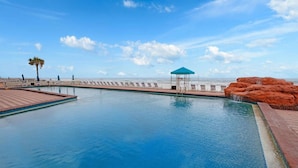 A swimming pool with a blue canopy and a view of the ocean. - Heated Oceanfront Pool + Hot Tub | Ocean View Studio | Free Daily Activities (Daytona Beach)