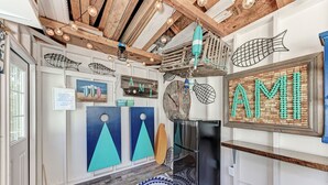 Un corridoio con decorazioni a tema nautico, tra cui opere d'arte e un frigorifero.