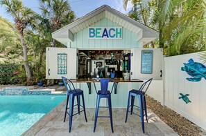A beach-themed bar with a poolside seating area.