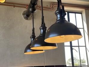 Three pendant lights hang from the ceiling, complemented by a large window with an outdoor view.