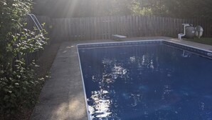 A rectangular swimming pool with a wooden deck surrounding it. - s1. Beautiful home in historic Scottsboro w/ pool (Scottsboro)