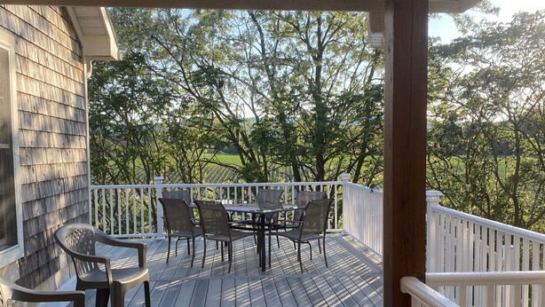 A wooden deck with a table and chairs, surrounded by white railings, overlooking a green landscape. - Just 3 miles Cooperstown, Hall of Fame, 2.5 miles to Baseball Dreams Park. (Cooperstown)