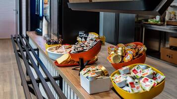 A buffet area with various food items and condiments.