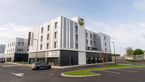 A modern hotel building with a sign reading "HOTEL OUVERT". - B&B HOTEL Poitiers Aéroport (Biard)