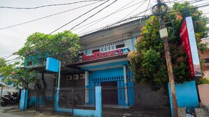 A building with a blue facade and a sign reading "RedDoorz". - RedDoorz Syariah near Margonda Raya (Depok)
