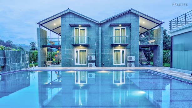 A modern building with a swimming pool in front. - The Cloyster Resort and Spa (Ramnagar)