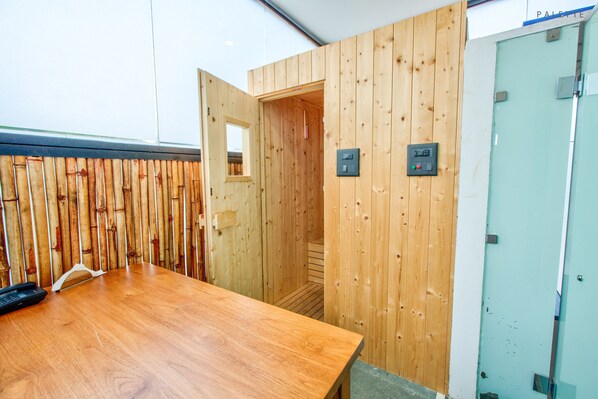 A wooden interior with a wooden table, a door, and a switchboard.